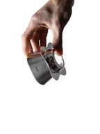 A person holding a silver, polished stainless steel Orea O1 brewer. The image showcases the raw metallic finish and the double-walled, unibody construction of the coffee dripper.
