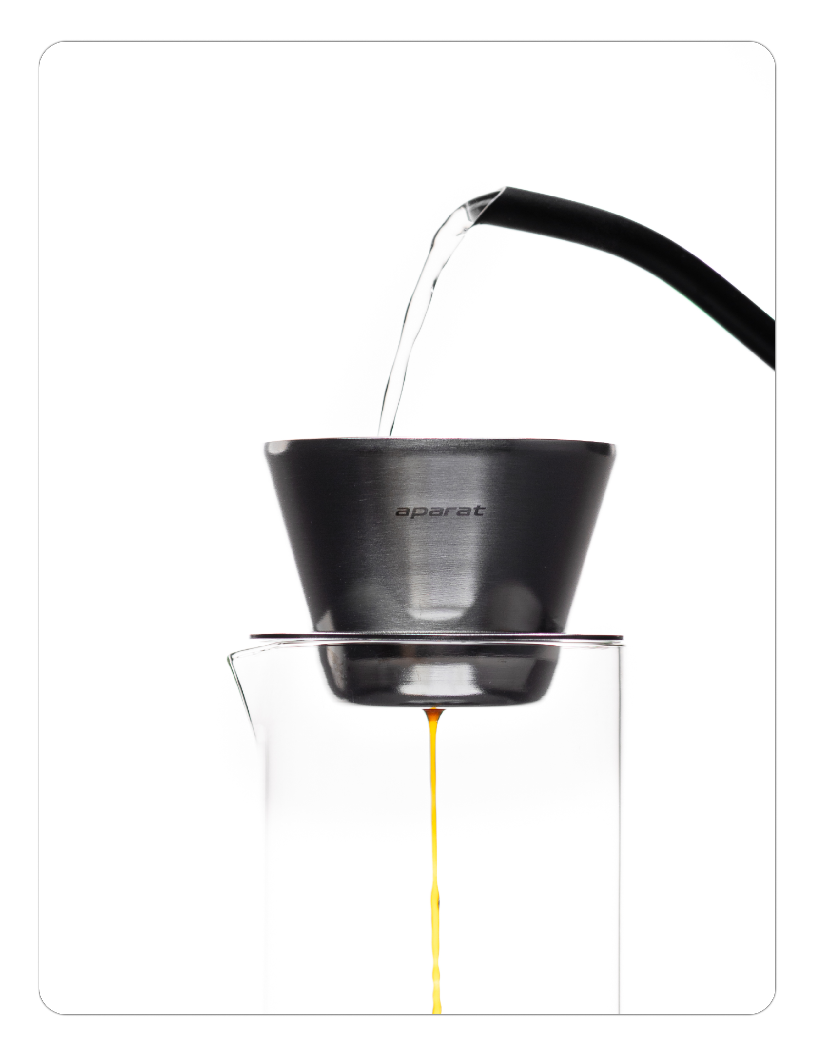 A person pouring water from a silver gooseneck kettle into a silver Orea O1 brewer. The water hits a paper filter inside the industrial raw steel cone, with brewed coffee visible dripping into a glass server below.
