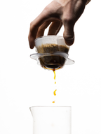 Hand holding orea dripper dripping coffee