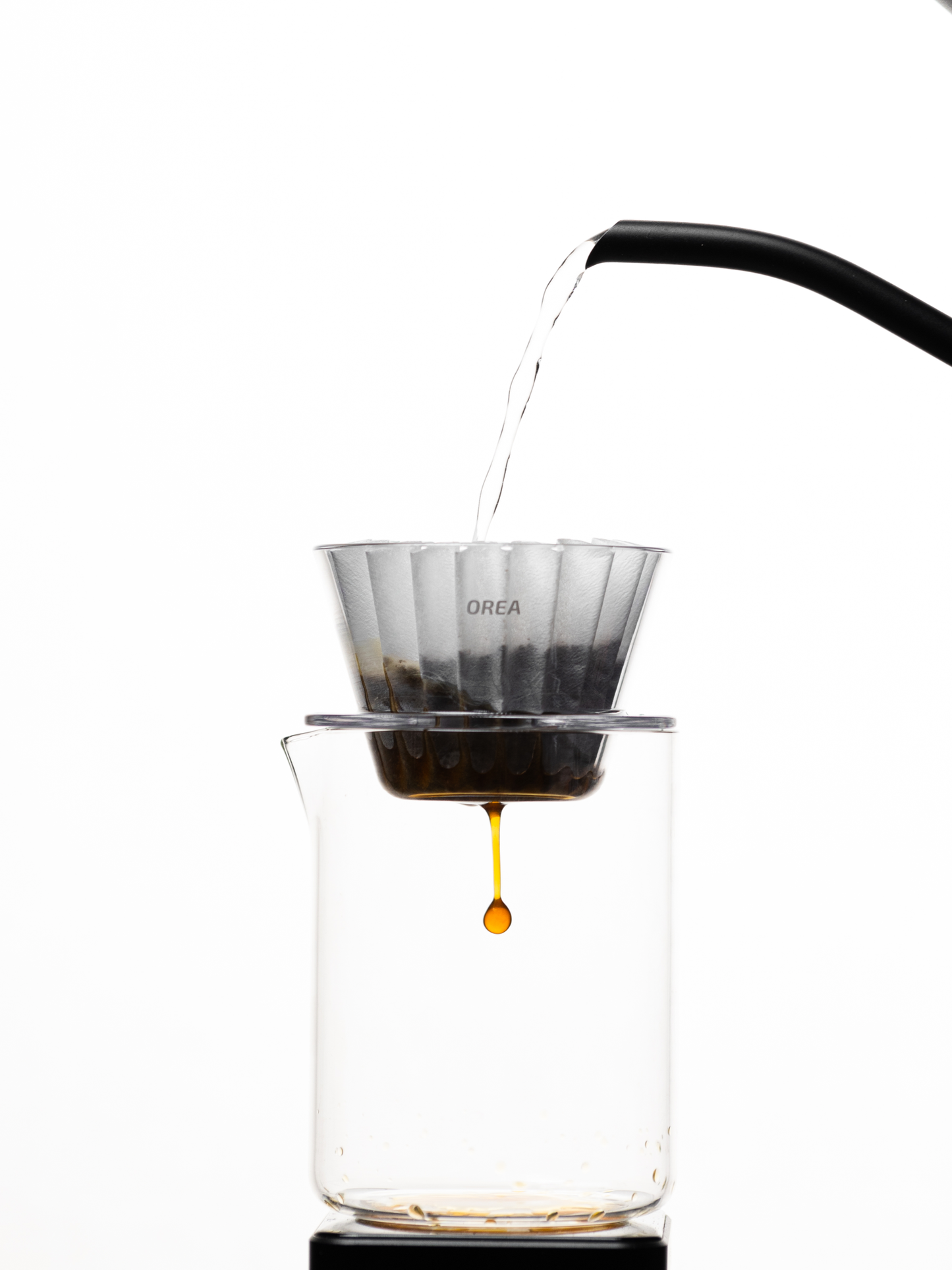 Hot water being poured into the Orea V1 brewer with coffee grounds.