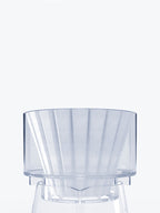 A close-up shot of the transparent Bathtub Simplify Brewer with a paper filter inside, resting securely on the rim of a glass decanter.