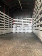 Stacked white grain-pro bags filled with premium green coffee beans, loaded into a transport truck and ready for export from Laboyani Farm in Pitalito, Huila, to Somewhere Coffee.