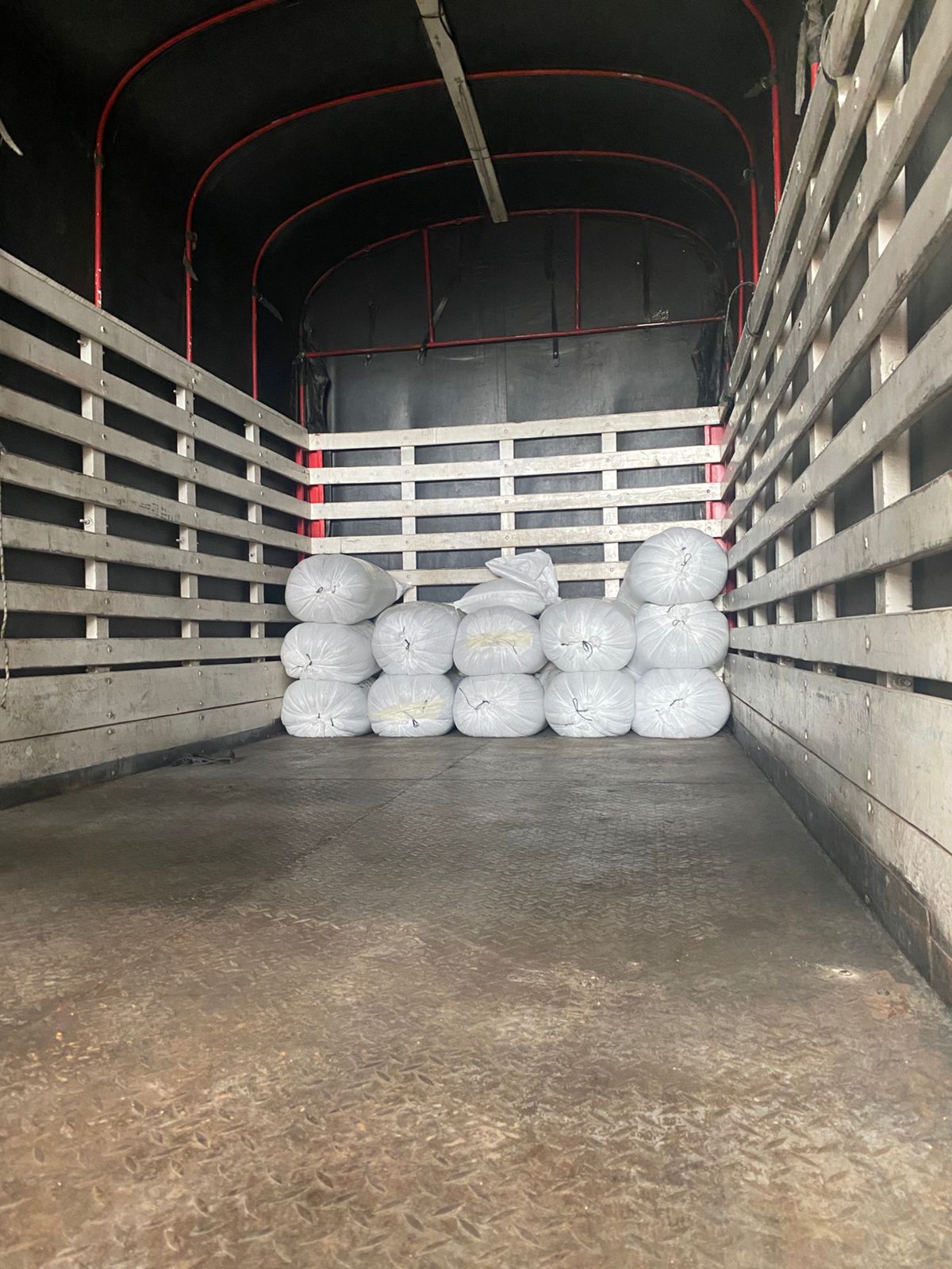 Stacked white grain-pro bags filled with premium green coffee beans, loaded into a transport truck and ready for export from Laboyani Farm in Pitalito, Huila, to Somewhere Coffee.