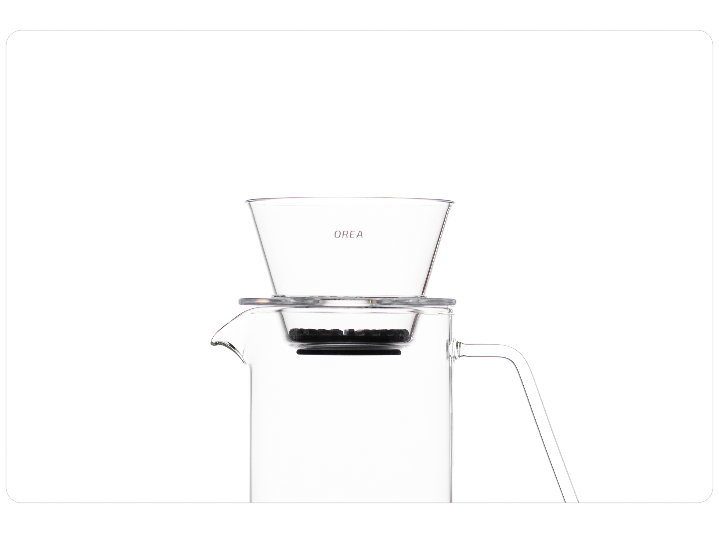 A clean studio shot of a clear OREA O2 brewer resting directly on the rim of a clear glass pour-over carafe, showcasing its flat-bottom design and universal fit for a seamless brewing setup.
