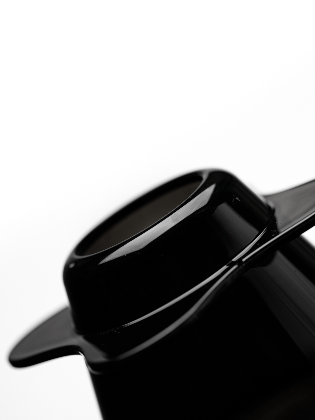 A macro profile shot highlighting the flawless, semi-transparent glossy black finish of the OREA O2 Darth Black Brewer, made from BPA-free Eastman Tritan plastic with zero injection marks.