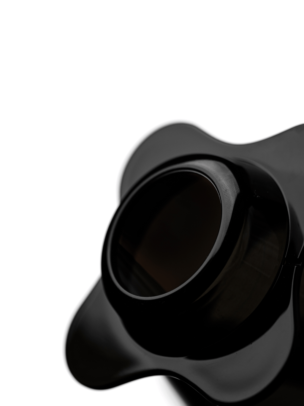 An extreme macro close-up of the OREA O2 Darth Black Brewer, showcasing the signature open bottom design and smooth, glossy unibody construction that allows the paper filter to bend naturally for even extraction.