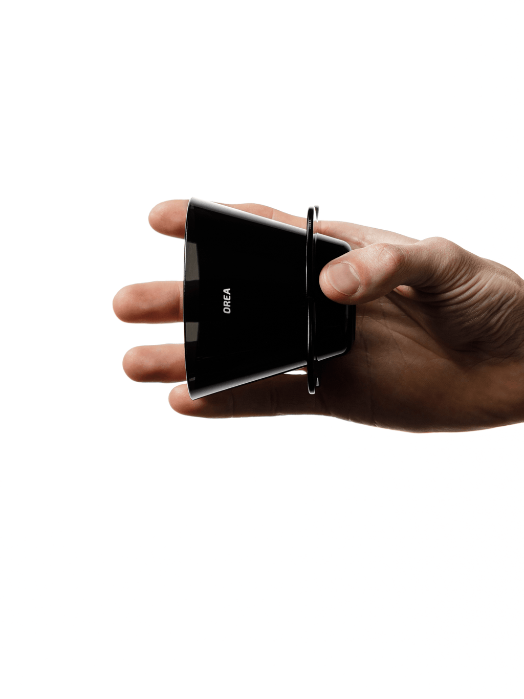 A hand holding the OREA O2 Brewer sideways, demonstrating its incredibly slim, lightweight profile at just 67 grams, making it a highly portable, travel-friendly coffee dripper.