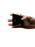 A hand holding the OREA O2 Brewer sideways, demonstrating its incredibly slim, lightweight profile at just 67 grams, making it a highly portable, travel-friendly coffee dripper.