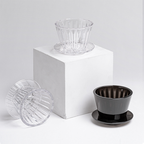 Studio product display of a Timemore B75 dripper in clear and amber black, positioned elegantly against a neutral background.