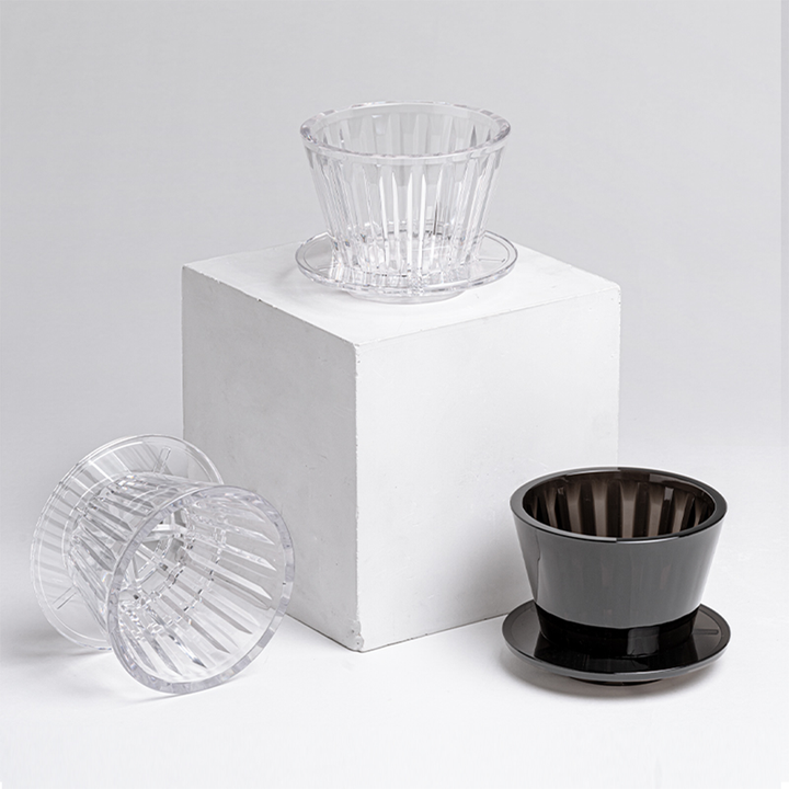 Studio product display of a Timemore B75 dripper in clear and amber black, positioned elegantly against a neutral background.
