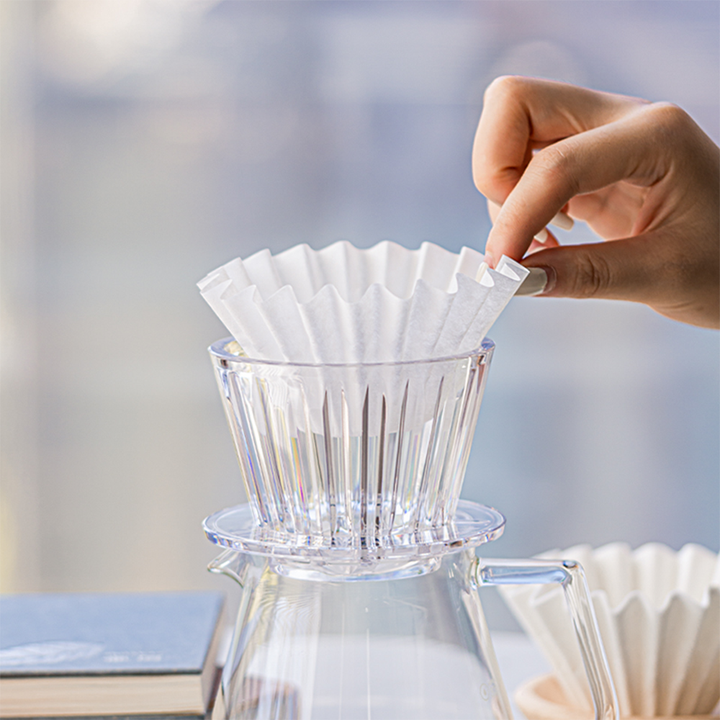 Timemore Crystal Eye B75 dripper with A white paper pour-over coffee filter inside.
